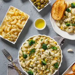 A creamy white sauce macaroni pasta with broccoli and corn. This top-down shot for Rakesh Masala showcases the dish and its ingredients in a clean, organized composition.