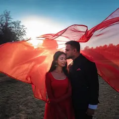 We incorporate elements like flowing fabrics to add movement and a touch of Bollywood-inspired drama to your pre-wedding photos. This shot uses a vibrant red cloth to create a dynamic and romantic frame.