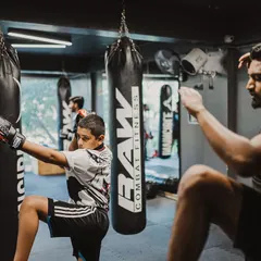 I mirror my student's movements during a Wai Kru practice session. This shows him the correct form and reinforces the deep respect we have for the traditions of Muay Thai.
