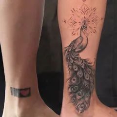 From a black box with a heart to an elegant peacock. This ankle cover-up shows that even dark, dense tattoos can be transformed into something beautiful and delicate with the right design and technique.