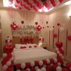 A full room view of a romantic birthday surprise, with balloons covering the ceiling and floor.
