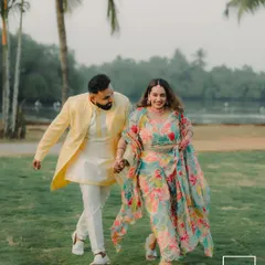 A happy, candid shot of a couple walking through a park, their colorful outfits adding a vibrant touch to the natural scenery.