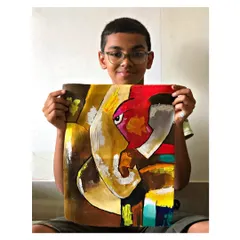 A student proudly displays his abstract Ganesha painting created using a palette knife. This modern interpretation is full of energy and texture.