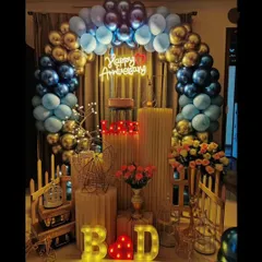 I designed this elegant anniversary decoration with a striking blue and gold balloon arch. The setup is personalized with the couple's initials in marquee letters and a romantic "Happy Anniversary" neon sign, creating a perfect photo backdrop for their special day.