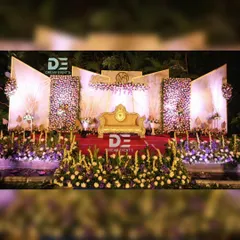 For this grand evening reception in Bengaluru, I created a multi-panel stage with dense floral walls and dramatic uplighting. The elegant gold sofa and intricate flower arrangements provided a luxurious focal point for the couple.