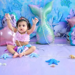 Playing with a string of pearls under the sea. The joy and wonder in her eyes are what make these themed sessions so special and memorable.