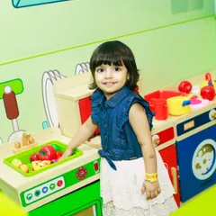 A little chef in the making! A toddler plays at our pretend kitchen station, complete with toy food and utensils to spark her imagination.