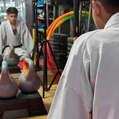 A student sits in meditation, reflected in the mirror. This practice builds mental toughness, focus, and the confidence that comes from inner calm.