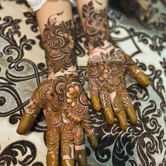 A complete set of intricate henna for both hands, ready for a special occasion. You can see how the patterns on each hand complement each other to create a full, beautiful look.
