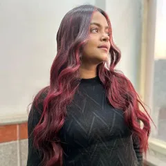 A beautiful example of a red ombre color melt. The color transitions from a natural dark root to vibrant red ends, styled in soft waves to showcase the blend.