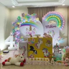 A wider view of the unicorn party, showing the light-up marquee number "4" and personalized name.