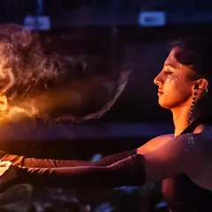 A moment of stillness and connection with the flame before the dance begins. This shot captures the calm focus required for fire spinning, a practice that is both meditative and exhilarating.