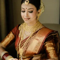 A moment of quiet contemplation before the ceremony. This classic portrait captures the bride's intricate makeup and jewelry, showcasing the timeless beauty of a Bengali bridal look.