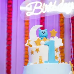 A close-up of a "twinkle twinkle little star" themed cake, with a neon "Birthday" sign in the background. These detail shots help preserve the overall vibe of the event.