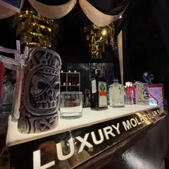 A close-up of our stylish bar counter, featuring our illuminated brand name and quirky, skull-themed tiki mugs.