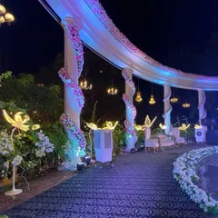 A closer look at the details of the reception stage. We wrapped the pillars in white florals and hung mini chandeliers to add a touch of opulence and romance to the decor.