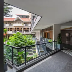 A view from a corridor in the Koramangala Club annexe, looking into a lush central courtyard. We designed the building to forge new relationships with these green spaces, creating visual connections and moments of tranquility.