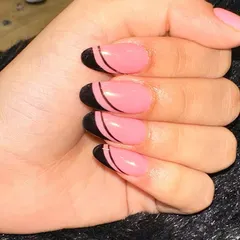A clean and graphic look with a pop of color. I used a bright pink base and added a bold black French tip with a thin, curved line separating the two colors for a modern, minimalist feel.