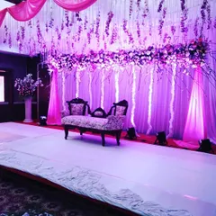 This angle shows the full effect of the hanging floral installation and stage lighting. This type of custom stage design transforms a venue into an immersive, thematic experience.
