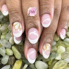 A classic French manicure with a golden floral twist. The clean white tips are elevated with a delicate, hand-painted gold flower on the accent nails.
