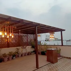 I can transform large terraces into functional outdoor living rooms. For this project, I designed and installed a custom wooden pergola to create a shaded seating and entertainment area, complete with rustic rope lighting and a dedicated bar space.