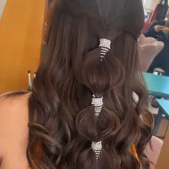 A modern and glamorous take on the half-up style. I created a bubble-effect ponytail with the top section of hair, using sparkling rhinestone cuffs to add a touch of bling. The rest of the hair is styled in voluminous waves.