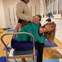 Providing a gentle, hands-on adjustment to a student in Geneva. I believe in giving personal attention to each practitioner, ensuring they practice safely and effectively, no matter their level of experience.