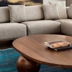 The beauty of natural wood is highlighted in this close-up of the oval coffee table in the West Coast Residence. The rich grain and smooth finish invite touch.