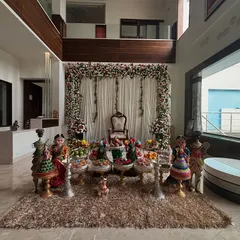 A wider shot of the home engagement decor, showing the full floral arch and offering table arrangement.