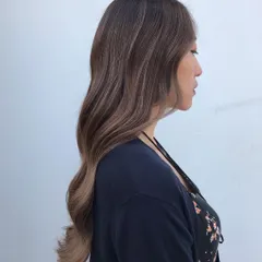 This side profile shows how the signature balayage frames the face and adds dimension without harsh lines. The transition from the dark roots to the lighter ends is smooth and natural.