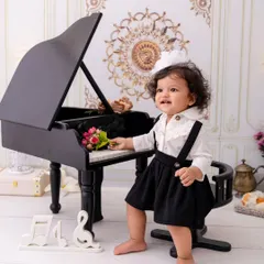 A little maestro in the making. This portrait captures a child's natural curiosity as she explores the miniature piano.