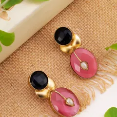 A pair of contemporary earrings with pink and black stones, styled on a natural jute surface with green leaves. This composition gives the product an organic, earthy feel, perfect for lifestyle-oriented brands.