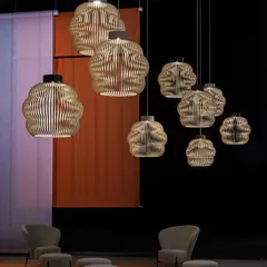 A large cluster of Seppo Koho's cloud-inspired pendants creates a captivating statement in this lounge area. The arrangement feels like a floating sculpture, filling the vertical space with warmth and texture.