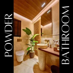 We designed this powder room to create a luxurious experience for guests. The space features a freestanding pedestal sink, warm marble walls, a wood-paneled ceiling, and a large plant to add a touch of nature.