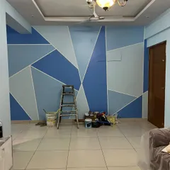 A living room accent wall featuring a large-scale geometric design in multiple shades of blue and grey, creating a cool and calming modern aesthetic.