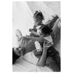 A quiet moment amidst the playful chaos. Even during a messy paint session, there are tender interactions that show the deep love between a mother and her children.