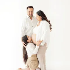 A big sister's gentle kiss for her unborn sibling. Family maternity sessions are a wonderful way to make older children feel part of this special journey.