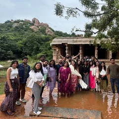 The group posing near a water-logged temple ruin in Hampi, a common sight during the post-monsoon season that adds to the site's beauty.