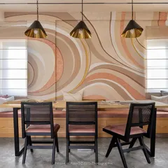 Our studio's conference room balances sophistication and creativity. The custom-painted abstract wall art in earthy pastels creates a soothing atmosphere, while the black-stained Chandigarh chairs provide a sharp, contemporary contrast for focused client meetings.