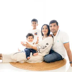 A relaxed family photo on the floor. This casual arrangement feels intimate and fun, showing the family's playful side in a bright studio setting.