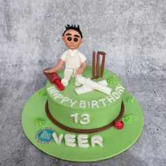 A perfect cake for a young cricket fan turning 13. This design features a green pitch, edible bat, ball, wickets, and a personalized cricketer figurine on top.