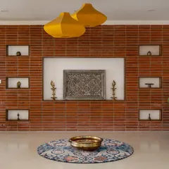 The journey into 'Vasudhalayah' begins in this foyer, where a wire-cut brick wall features carved niches for family heirlooms. The space is warm and personal, setting the tone for the rest of the home.