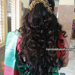 A gorgeous hairstyle with voluminous curls, perfect for a naming ceremony or any festive occasion. The half-up style is adorned with a beautiful gold and pearl hair accessory.