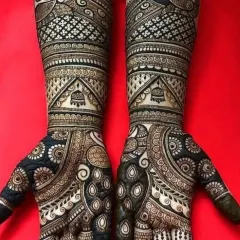 A bold and beautiful bridal design using heavy application for a dark, rich stain. The pattern features a mix of traditional Indian paisleys and geometric fills, covering the hands and forearms completely.