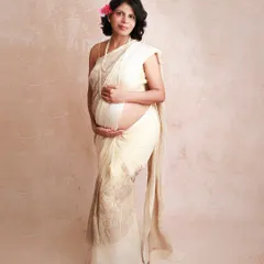 Draped in a simple, elegant saree with a flower in her hair, this mama shows the quiet strength and beauty of motherhood. This is a classic bare-belly shot that feels both traditional and personal.