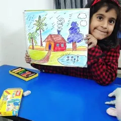 A young artist proudly presents her colorful landscape drawing, complete with a house, pond, and palm trees. Our classes help children build the skills to bring their imaginative scenes to life.