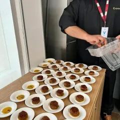 Behind the scenes of the seven-course meal. Here, my chef is carefully plating one of the appetizer courses, ensuring every dish is presented with precision and artistry.