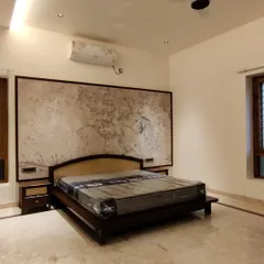 This bedroom features a large, custom-made textured art panel behind the bed. This type of decorative paneling can be adapted for home theatres to hide acoustic treatments and speakers.