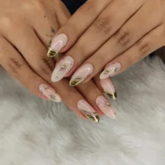 A sophisticated design combining a sheer, milky base with gold chrome tips, gold foil accents, and delicate starburst details with rhinestones.