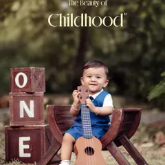 Innocence unveiled. This happy little musician is all smiles with his ukulele during his outdoor first birthday photoshoot.